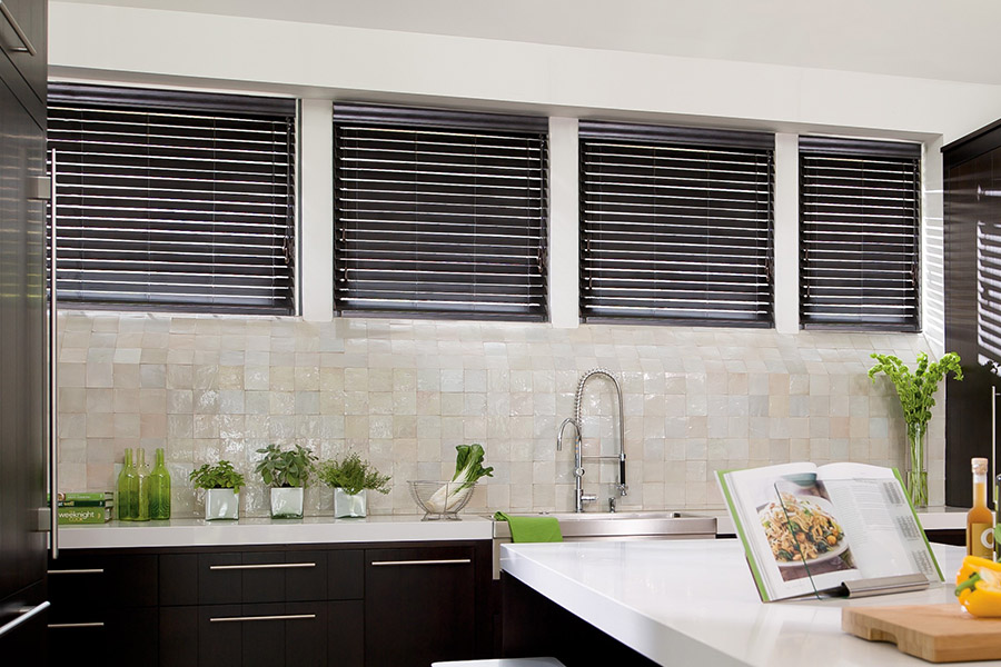Choose custom Polywood faux wood blinds for your kitchen in Chicago. Special shaped faux wood blinds in several windows above a sink.