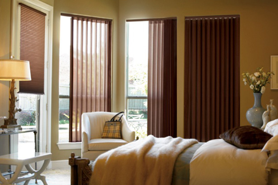 Choose durable and high-quality fabric or vinyl vertical blinds in Chicago. Maroon fabric vertical blinds inside a bedroom