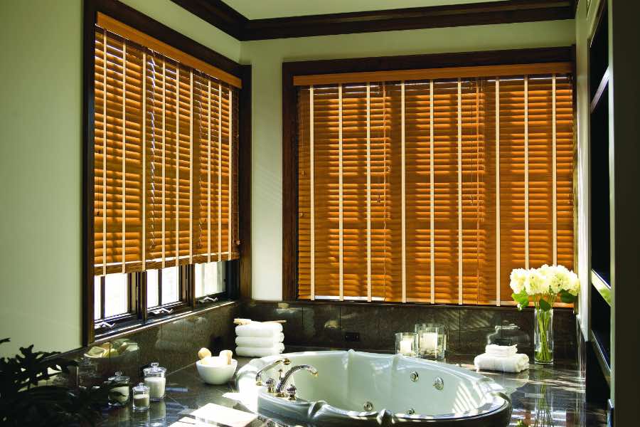 Premium quality blinds are always a stylish accent in your Chicago home. Brown wood blinds on large windows in a green bathroom