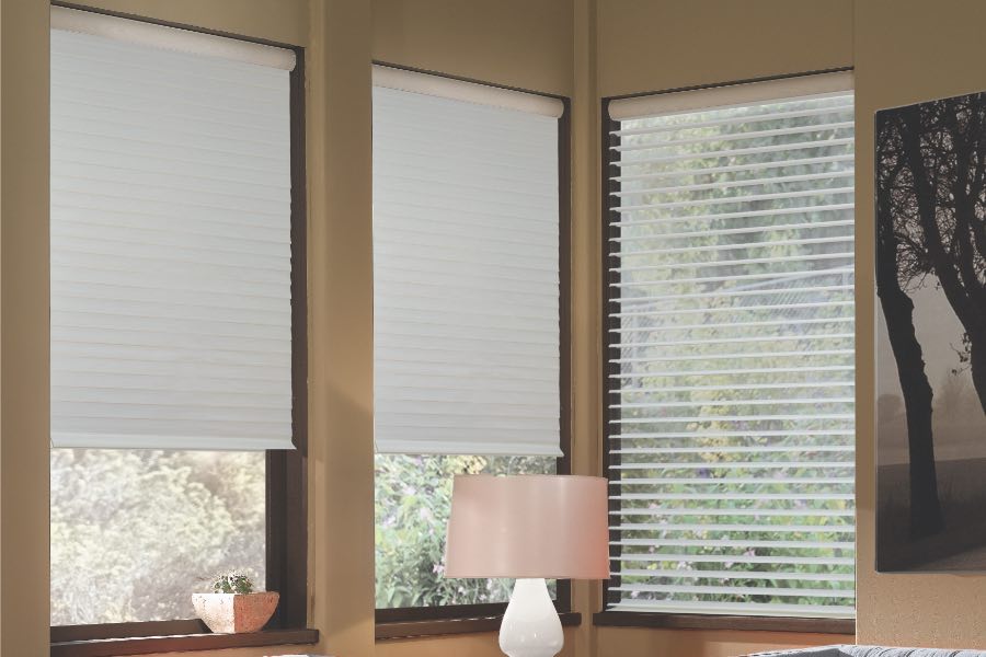 Opaque motorized window shades in Chicago keep hot UV rays out of your home. Gray motorized sheer shades on corner windows next to gray furniture