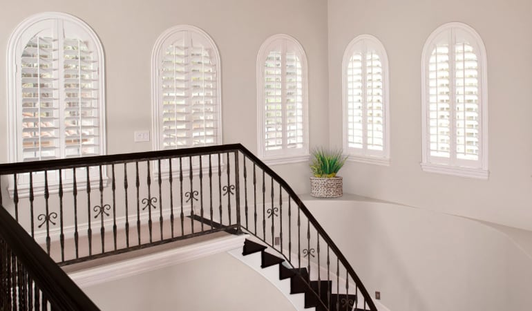 Interior shutters can be custom-fit to match unique shaped windows. Plantation shutters on uniquely shaped windows.