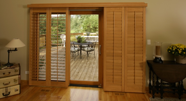 Wood shutters create a buffer that transitions from indoor wood to patio. Chicago wood shutter sliding door