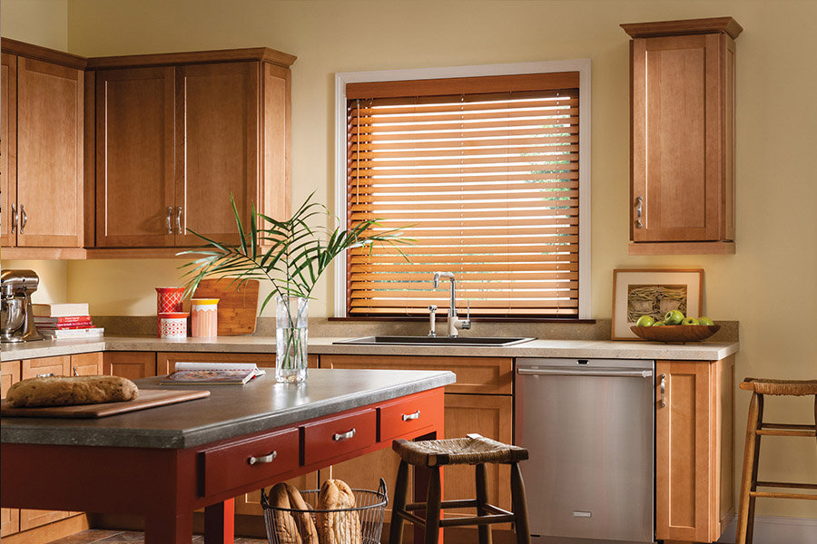 Waterproof faux wood blinds are durable and give you privacy and light control in your Chicago kitchen. Dark faux wood blinds above a kitchen sink