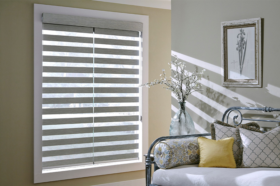 Find Practical and stylish window blinds for Chicago homes at Sunburst. Gray blinds on a large window next to a couch.