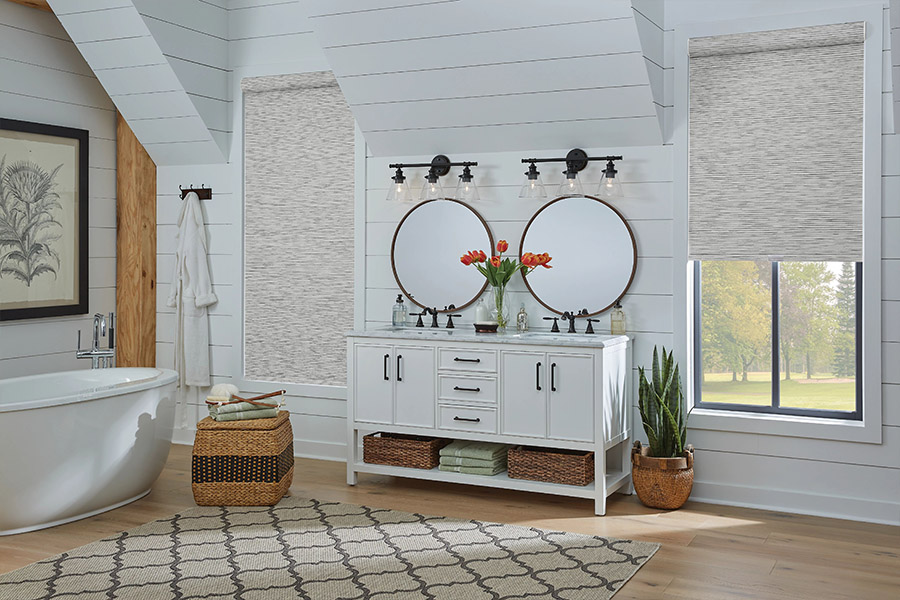 Slim-profile roller shades easily fit shallow windows in your Chicago home. Gray patterned roller shades on bathroom windows